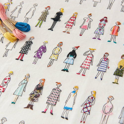 Close up of embroidered people in colorful dresses with on a white background