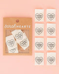 Heart-shaped sew-in labels with 'Thanks I Made It' text in a 'Sarah Hearts' packaging on a pink background