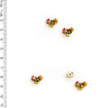 Four small decorative chicken buttons and one small white egg button with a ruler for scale on a white background