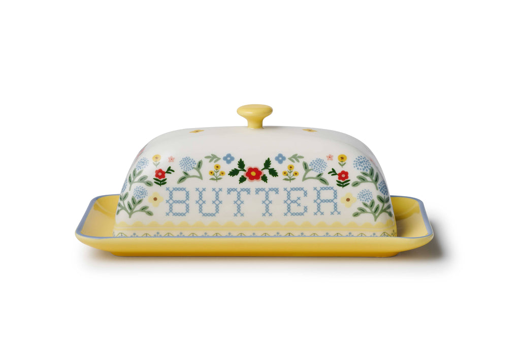 Decorative butter dish with floral patterns and the word 'BUTTER' on a white background