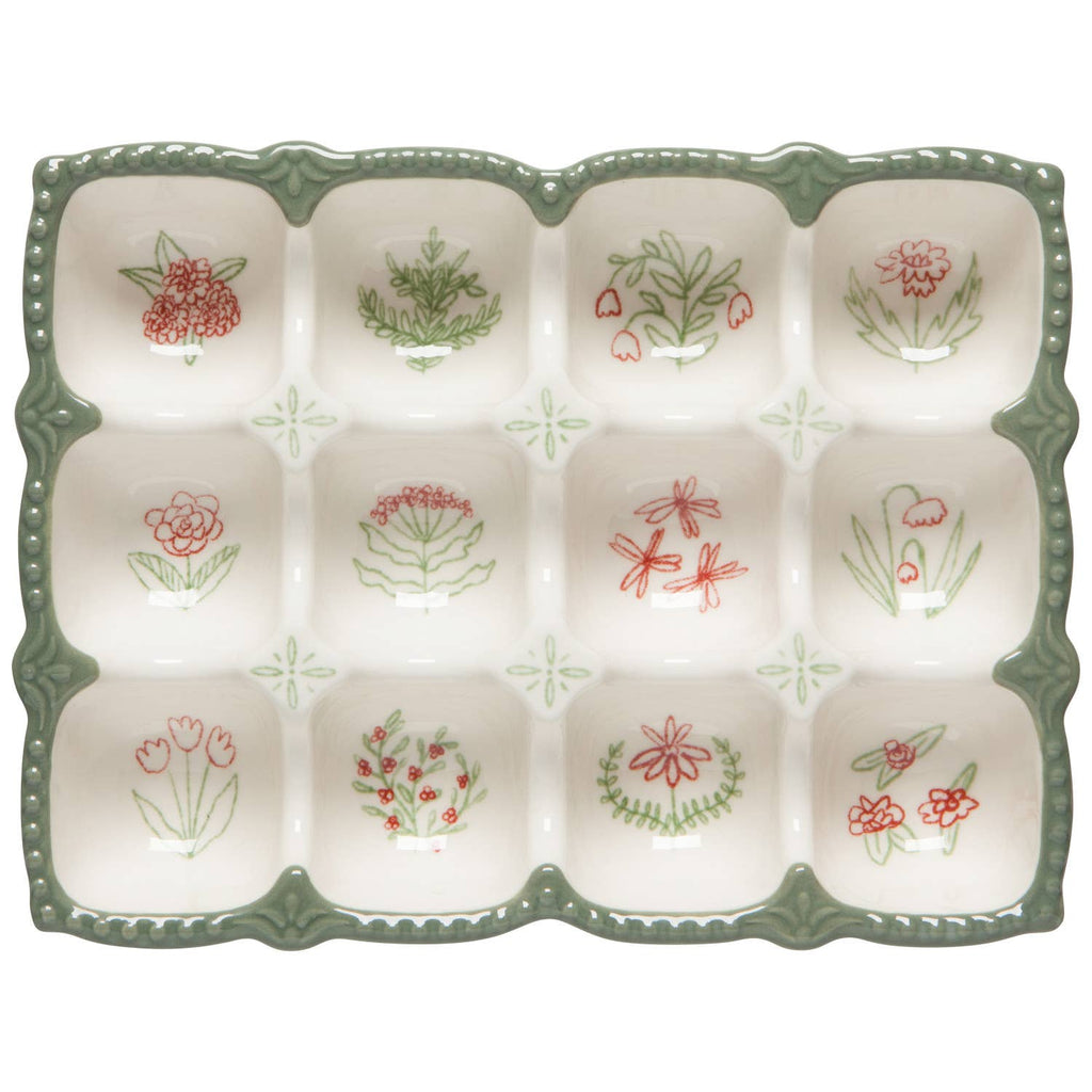 Decorative ceramic egg tray with floral patterns on a white background