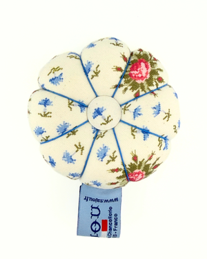 Floral-patterned pincushion on a white background