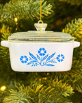Decorative pot ornament with blue floral design hanging on a Christmas tree.