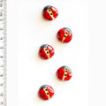 Red and black ladybug buttons with a ruler for scale on a white background