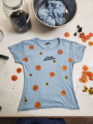 Short-sleeve light blue cropped baby tee shirt with floral pattern naturally dyed by flowers with "Inner Grandma" text