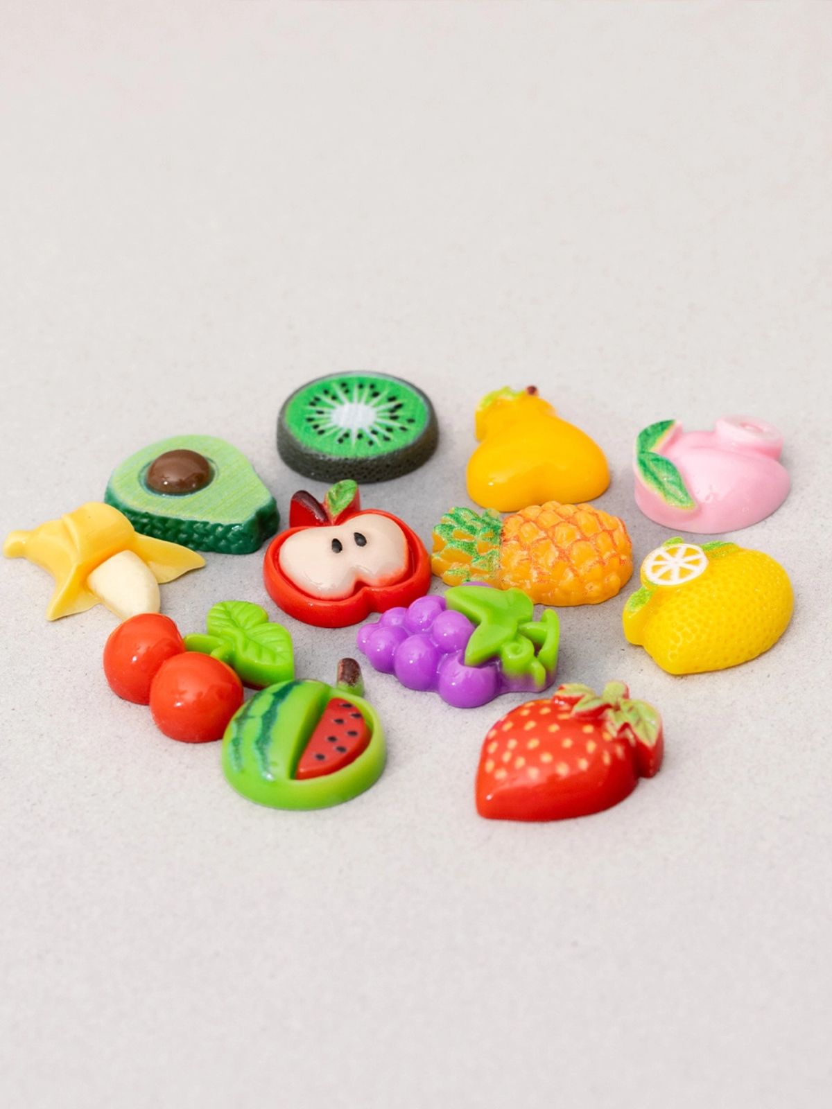 Colorful fruit-shaped erasers on a light gray background