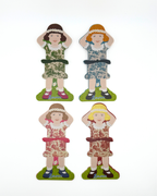 Four paper doll thread storage with different dresses on a white background