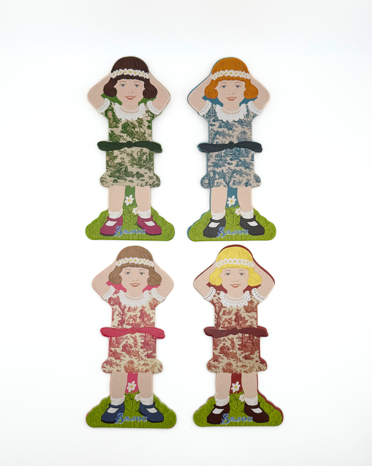 Four paper doll thread storage with different dresses on a white background