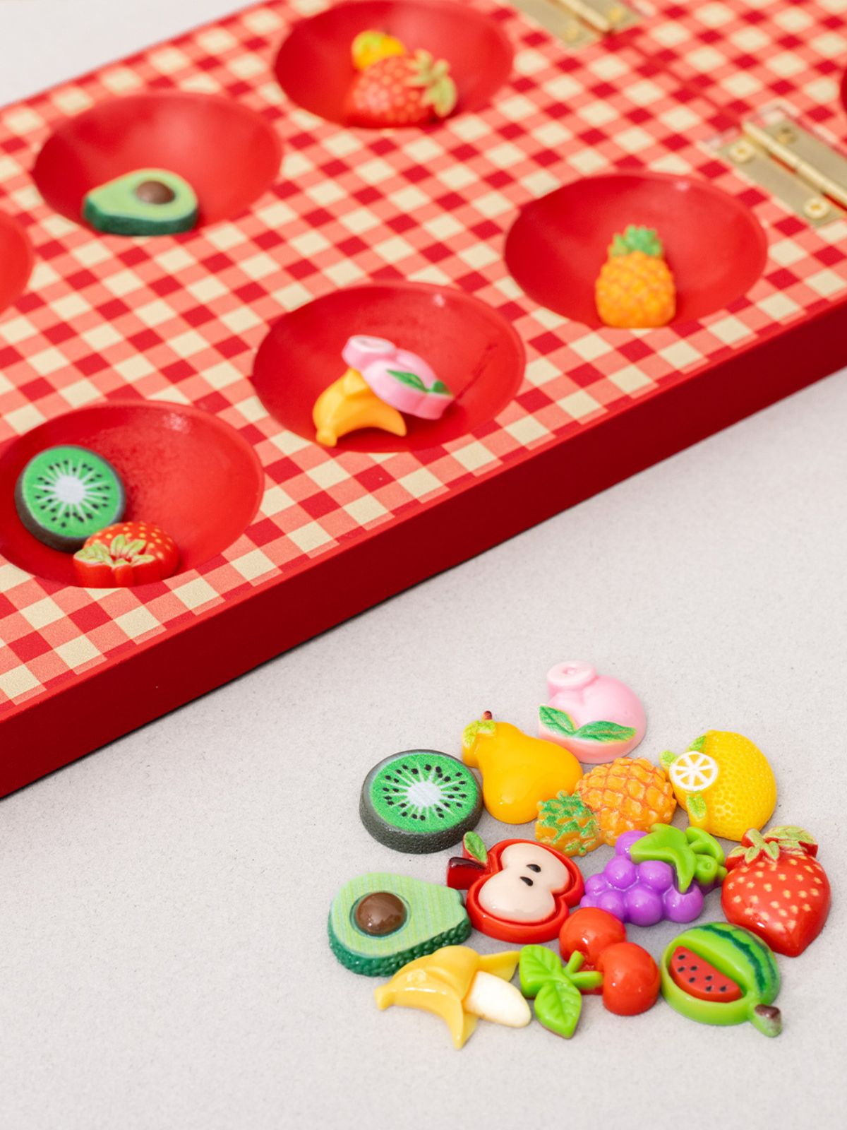Colorful fruit-shaped toys on a red checkered board