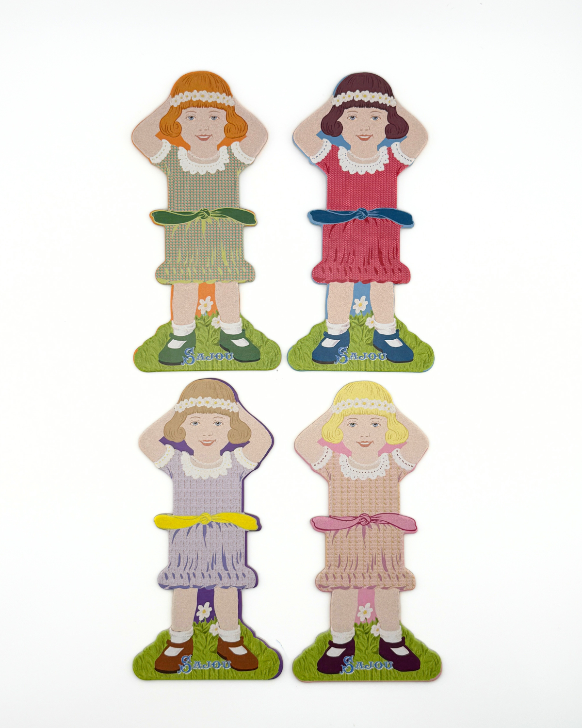 Four paper doll thread storage with different dresses on a white background