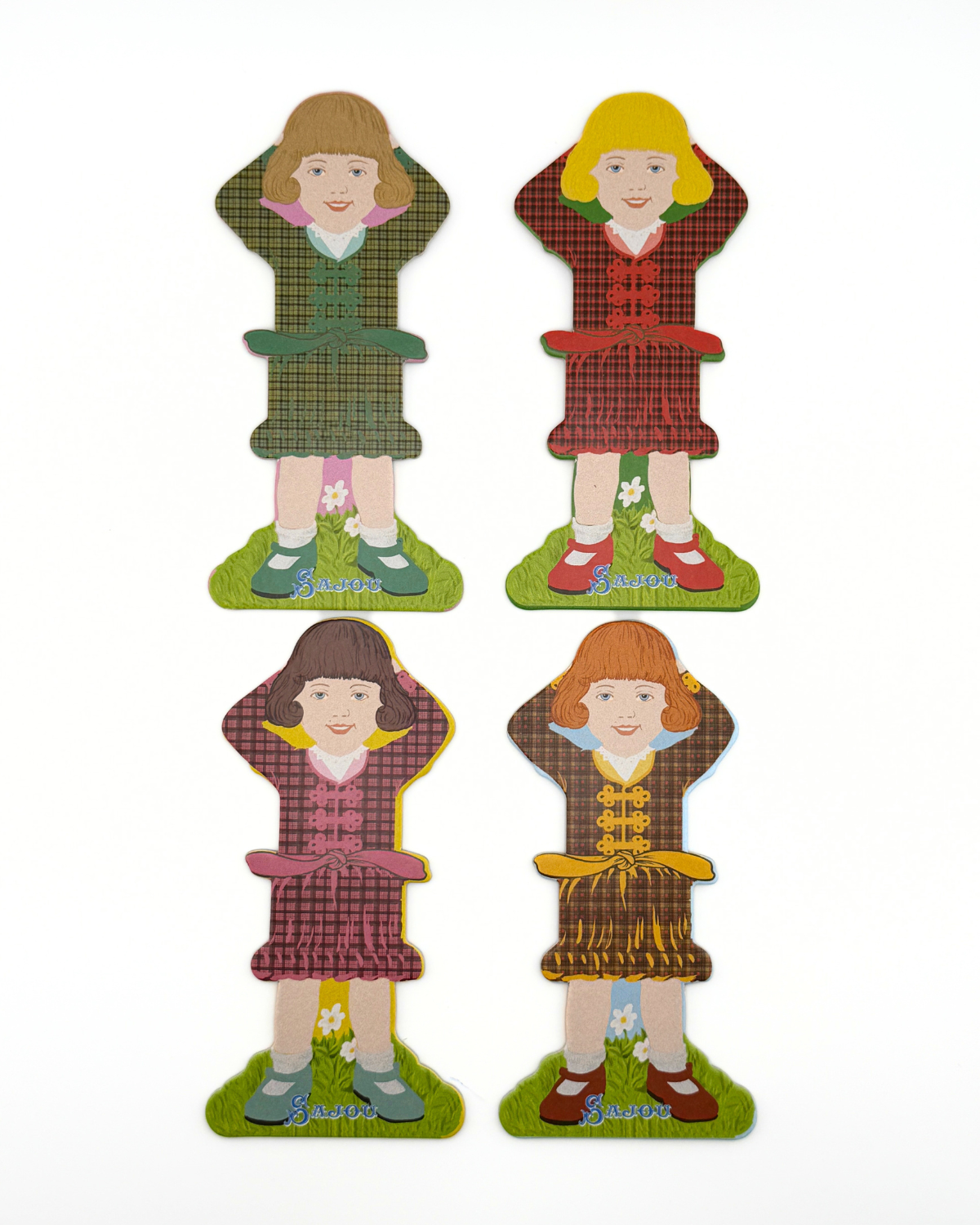 Four paper doll thread storage with different dresses on a white background