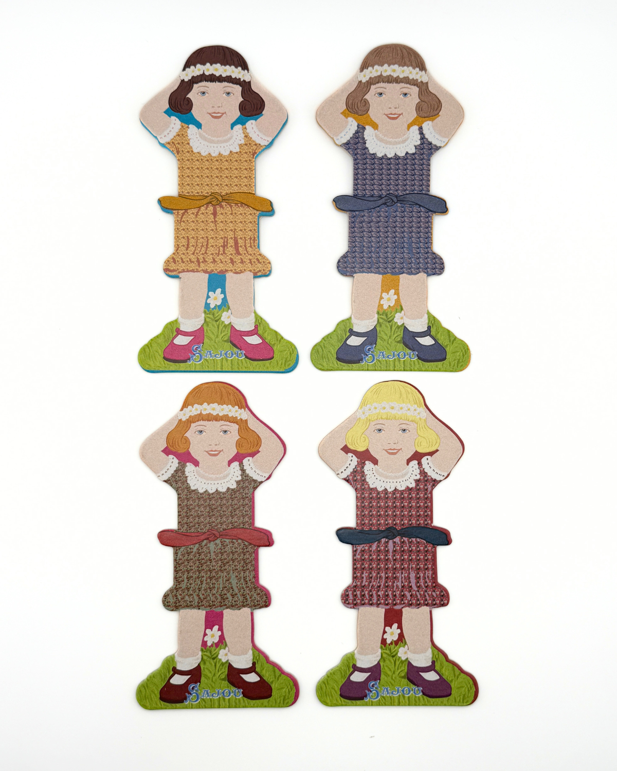 Four paper doll thread storage with different dresses on a white background