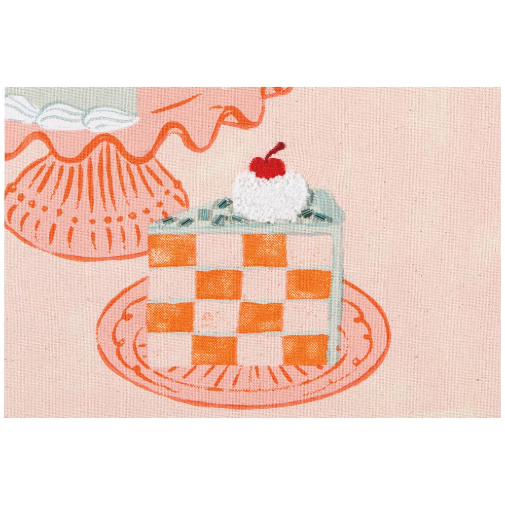 Checkered cake with whipped cream and a cherry on top on a pink background