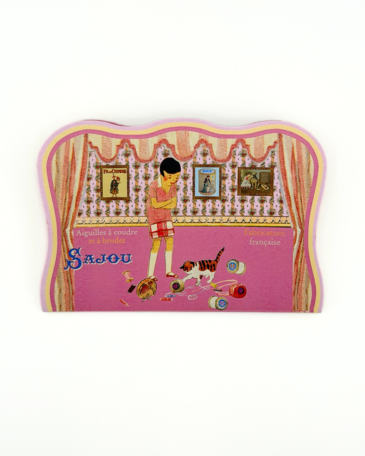 Decorative needle case with a design of a woman and dog, featuring the brand 'Sajou'.