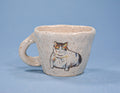 Ceramic mug with a cat illustration on a blue background