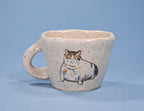 Ceramic mug with a cat illustration on a blue background