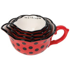 Set of red polka dot measuring cups with black handles on a white background