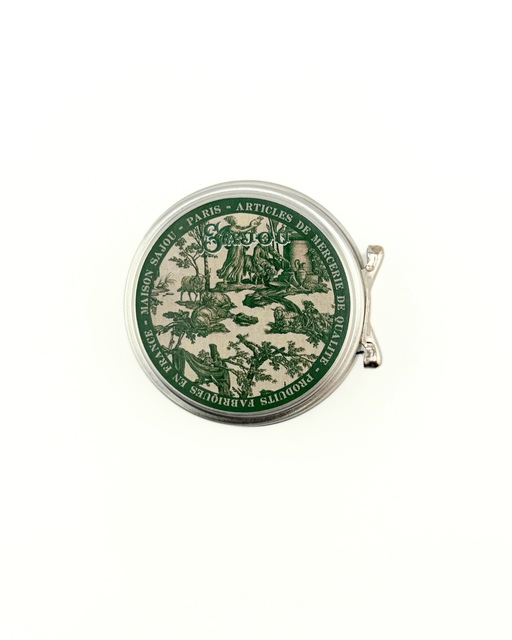 Round green and beige tin with decorative design on a white background