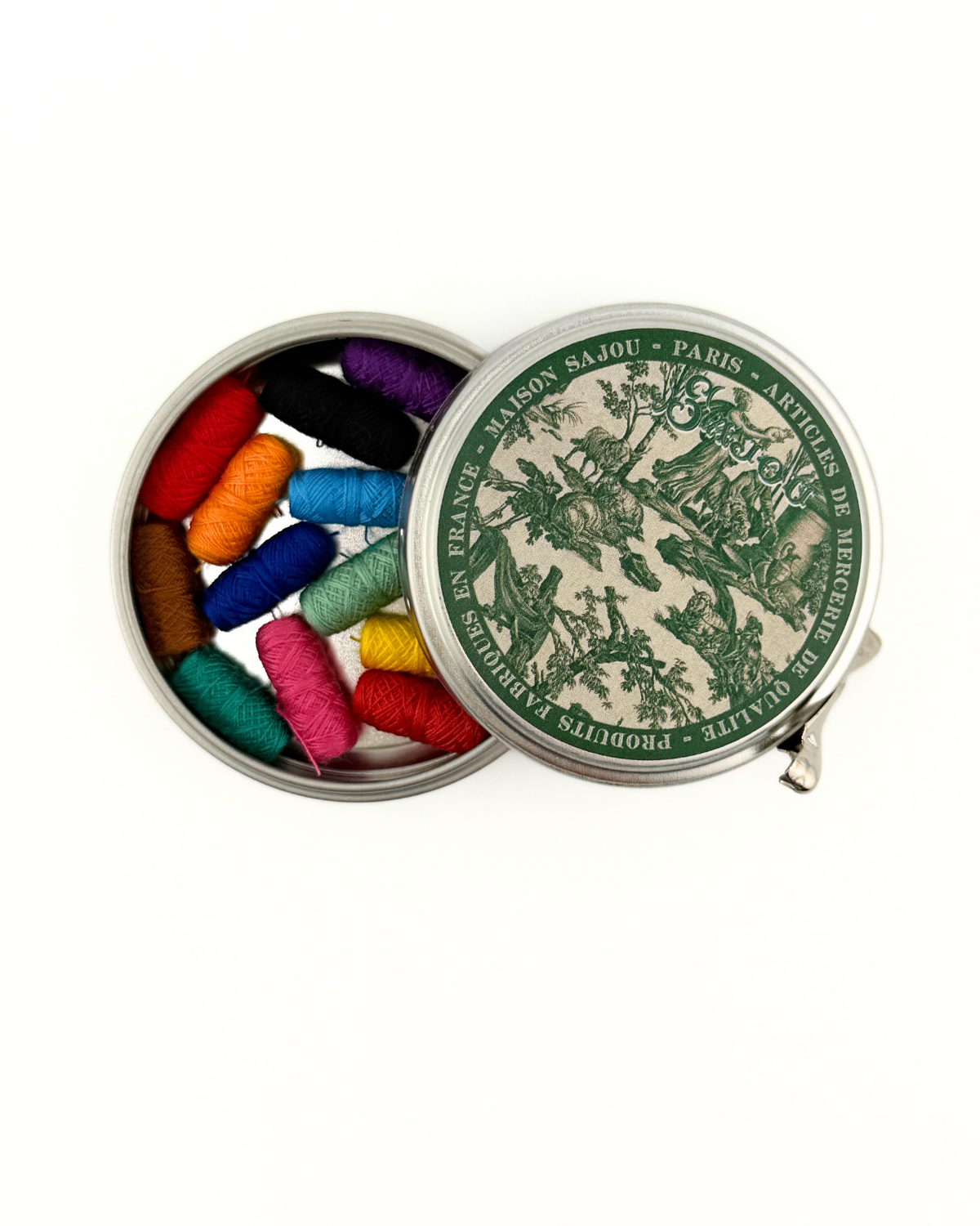 Small tin with colorful thread spools and a decorative lid on a white background