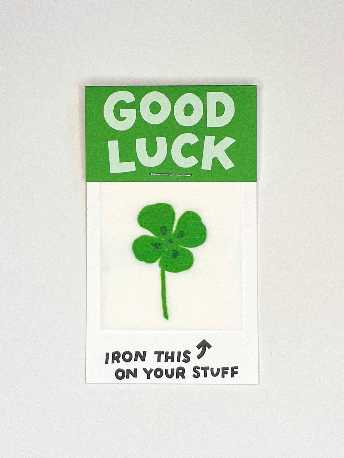 Iron on patch with a green four-leaf clover design on a white background