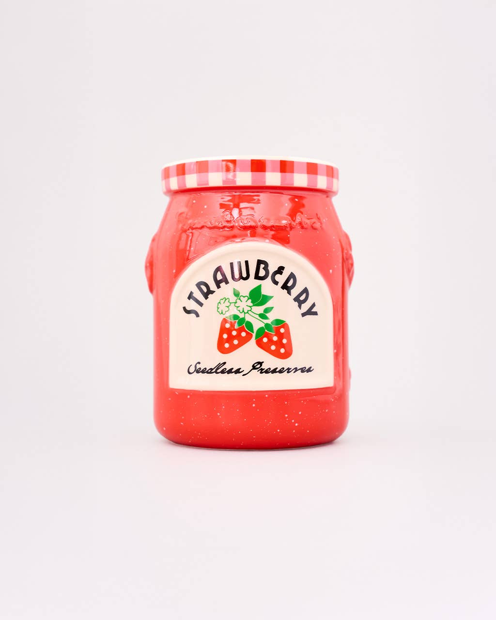 Red jar with strawberry preserve label on a light gray background