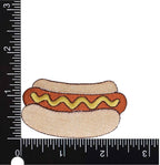 Embroidered hot dog with mustard on a bun next to a ruler for scale