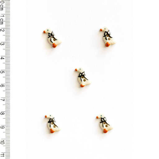 Five tiny geese-shaped buttons on a white background with a ruler for scale.