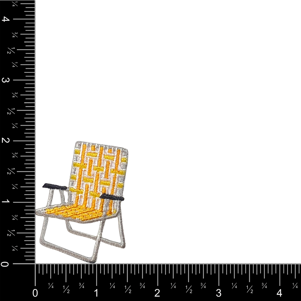 Small yellow and gray chair patch next to a ruler for scale on a white background