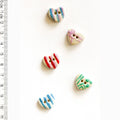 Colorful heart-shaped buttons on a white background with a ruler for scale.