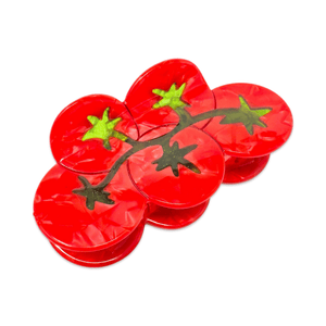 Red tomato-shaped claw clip with green stems on a white background