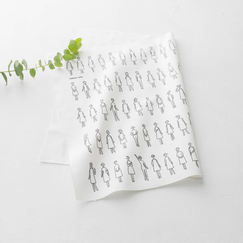 White fabric with black line art pattern of people wearing dresses on a white background