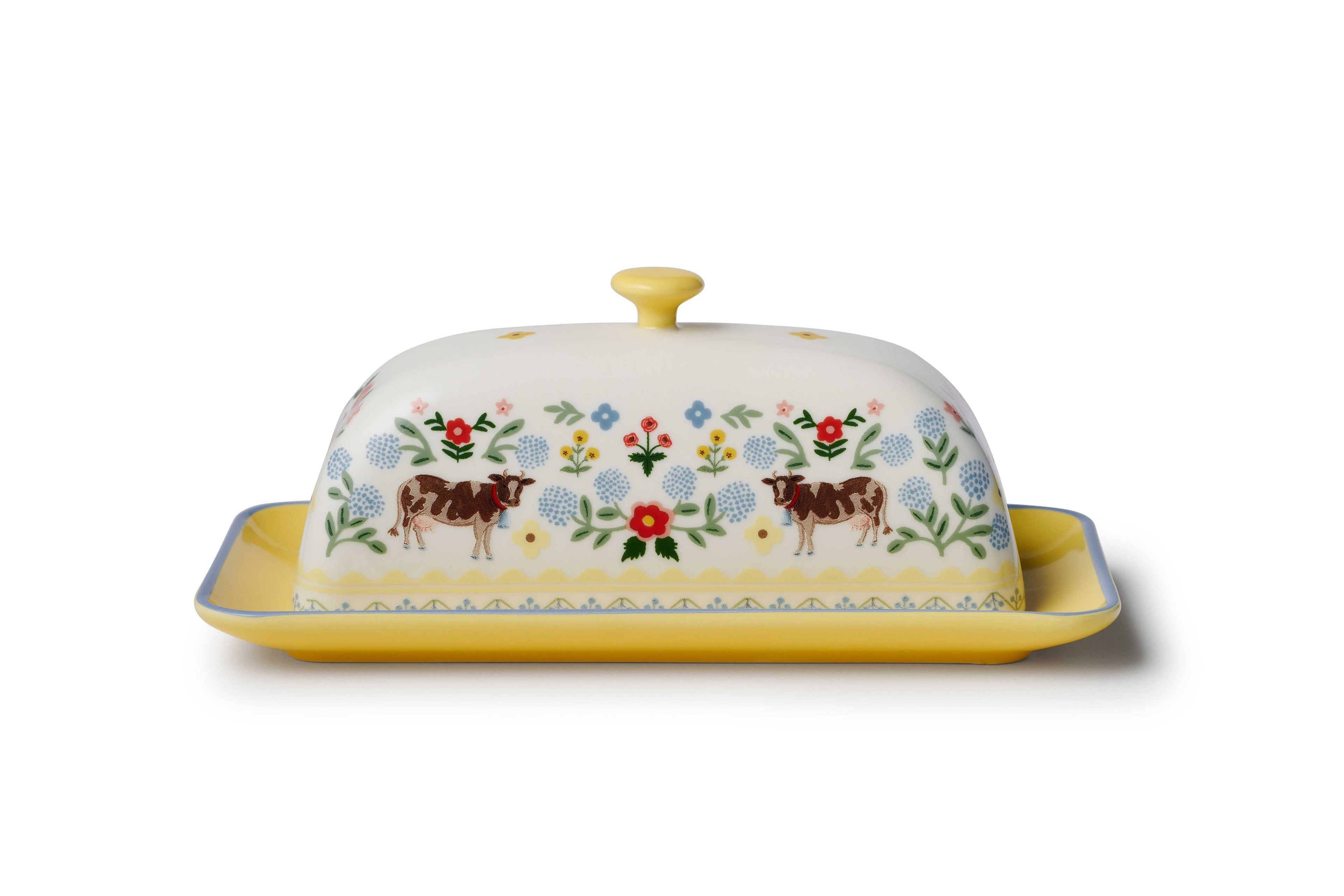 Decorative butter dish with cow and floral design on a white background