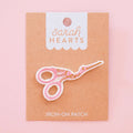Sarah Hearts Iron-on scissors patch with a pink background
