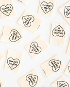 Small square tiles with heart-shaped text on a white background