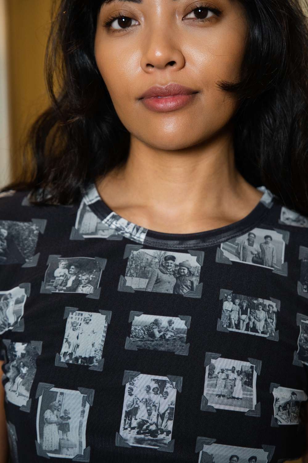 Person wearing black and gray mesh fabric top with printed black and white images of grandmas, people and objects.