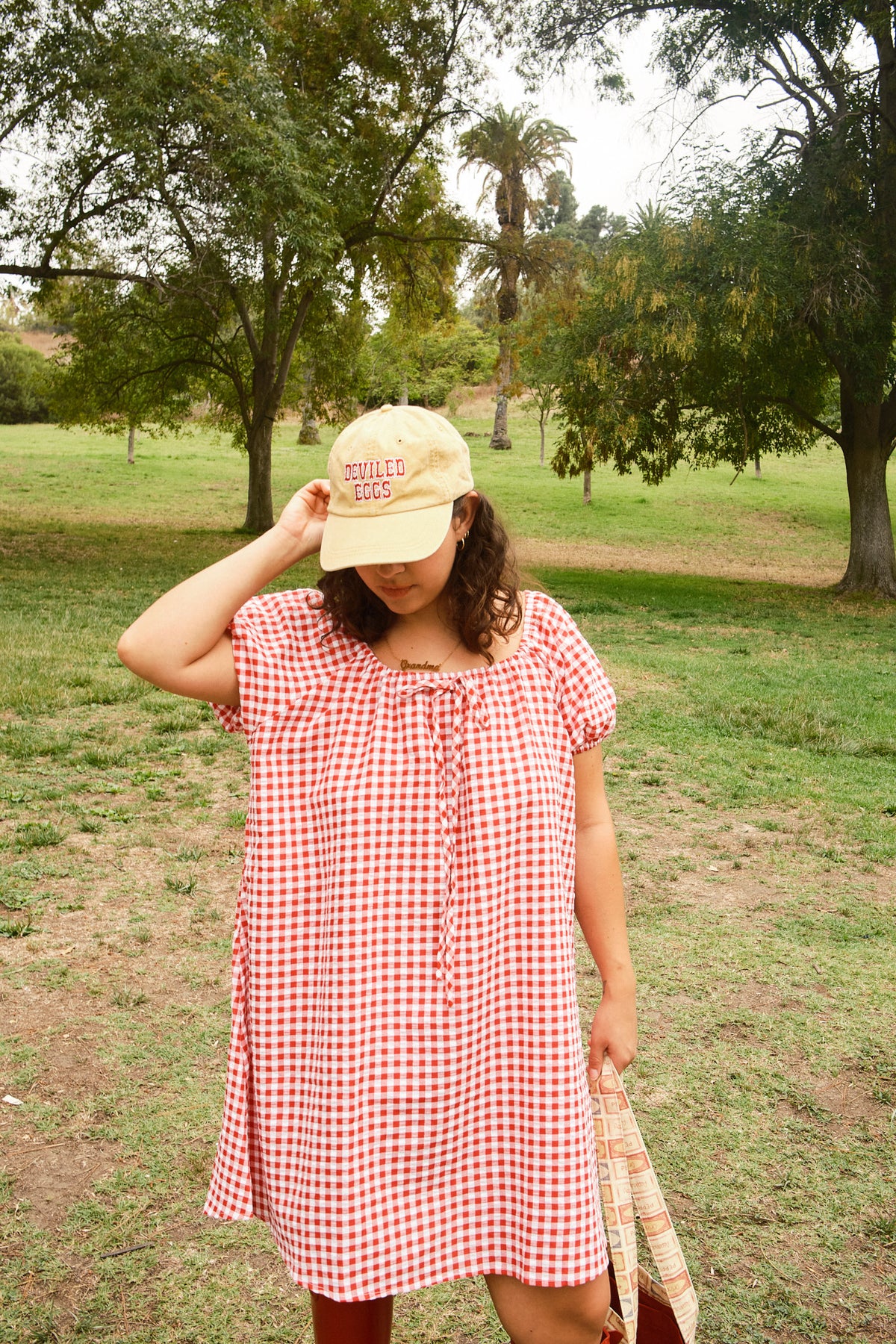 Person wearing a yellow hat with red "Deviled Eggs" lettering, and a red-and-white dress.