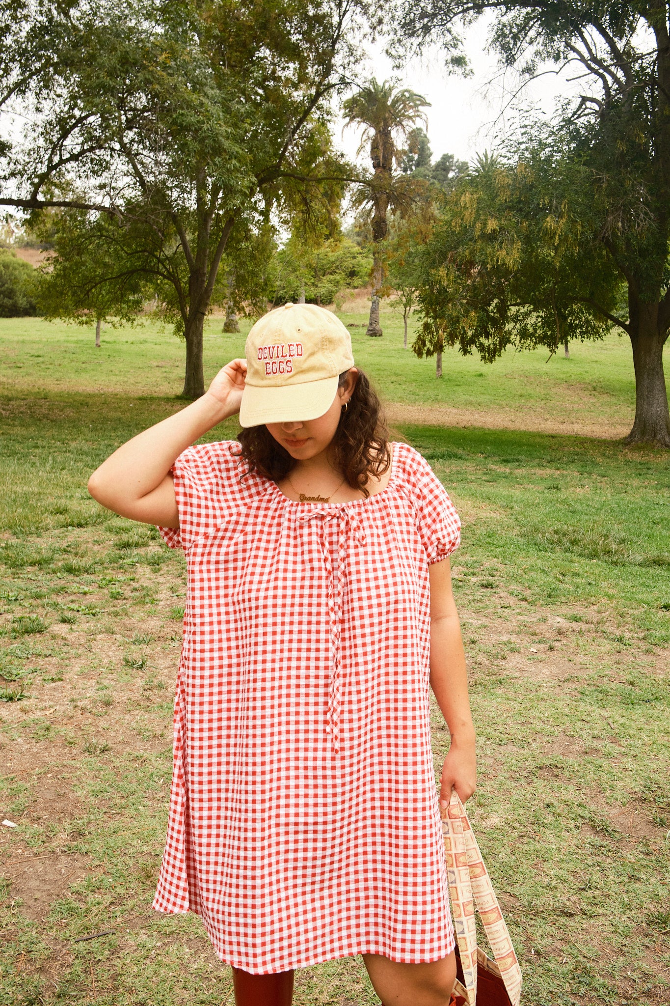 Person wearing a yellow hat with red "Deviled Eggs" lettering, and a red-and-white dress.