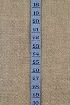 Blue measurement tape ribbon with numbers on a beige fabric background