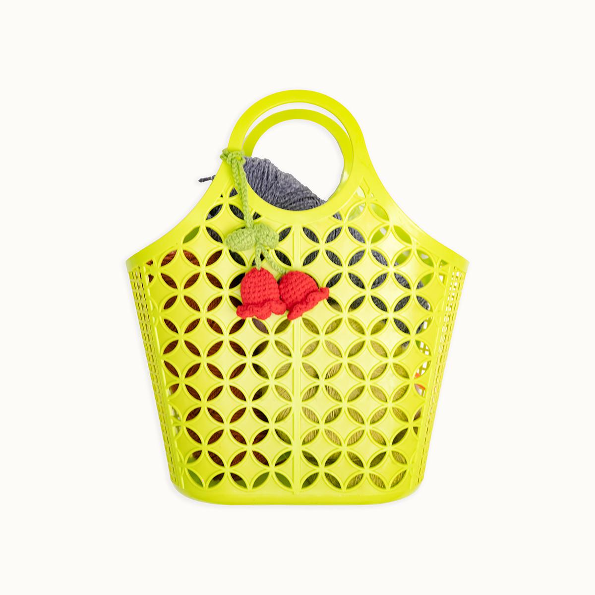 Yellow perforated handbag with red heart design on a white background
