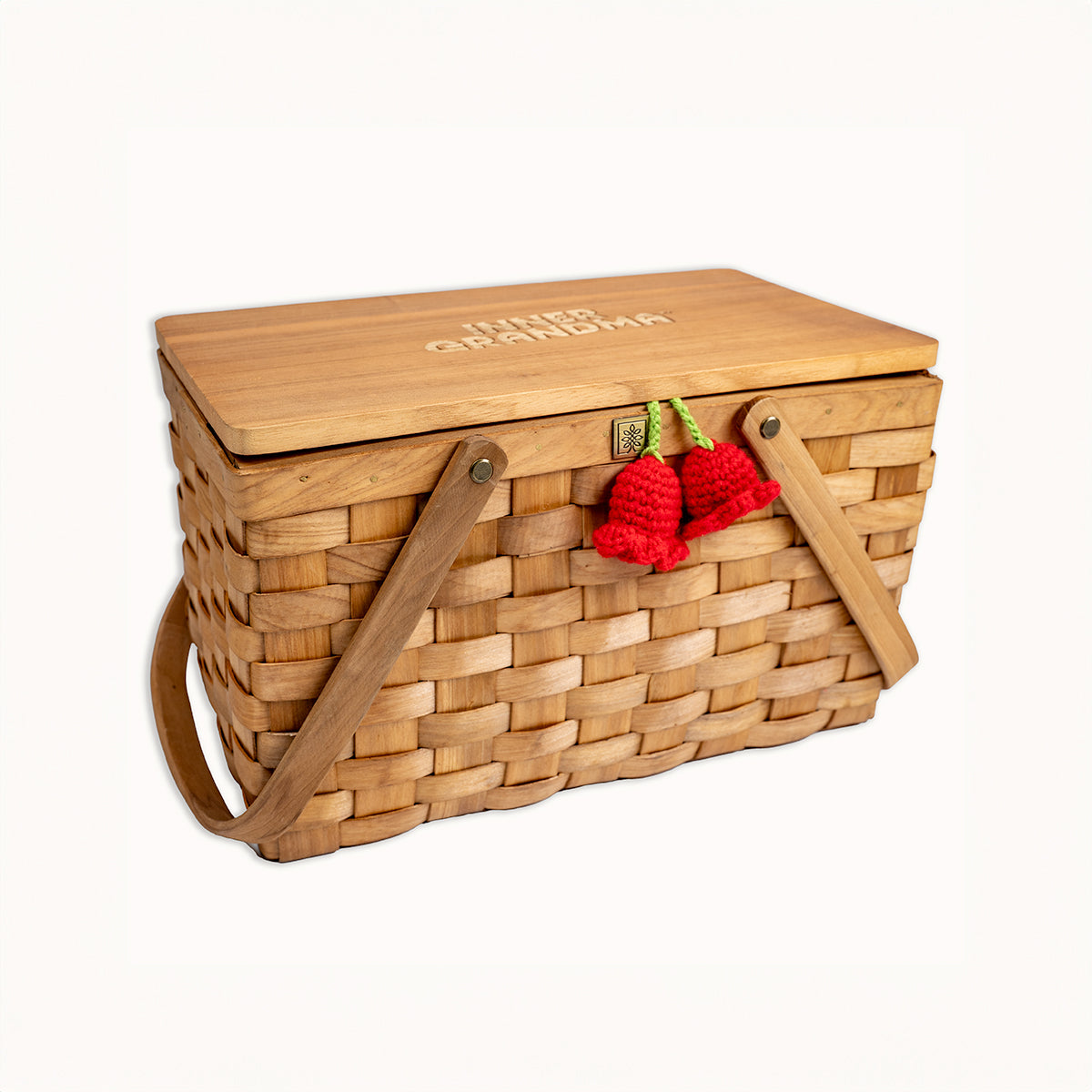 Wooden picnic basket with red cherry decorations on a white background