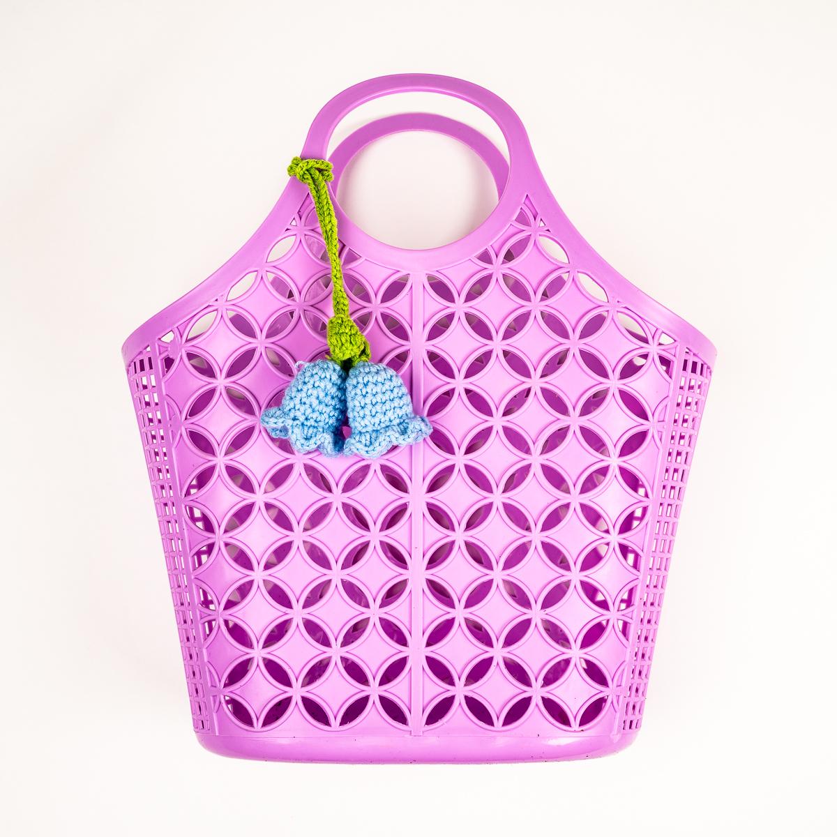 Pink silicone bag with a blue charm on a white background