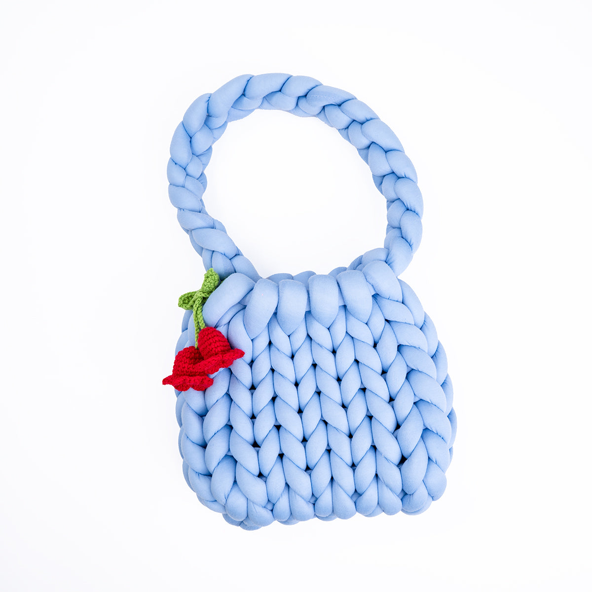 Blue braided toy with a red flower on a white background