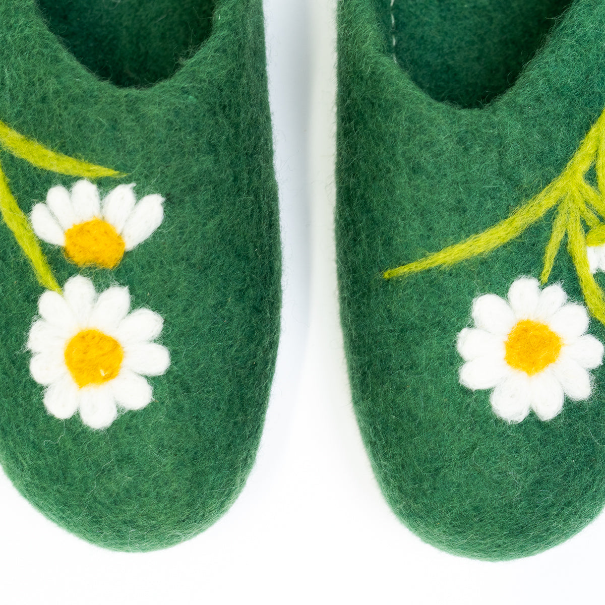 Green slippers with white daisy flowers on a white background