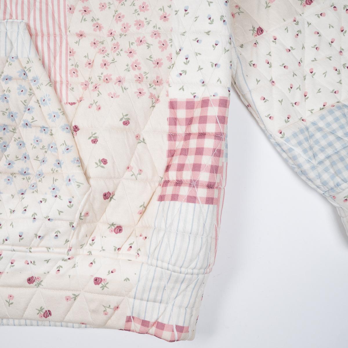 Patchwork quilt with floral, checkered, and striped patterns on a white background