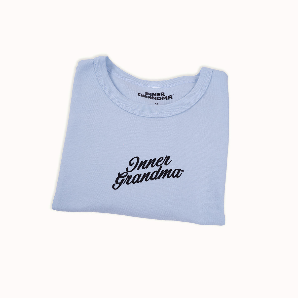 Light blue cropped baby t-shirt with 'Inner Grandma' text on a white background
