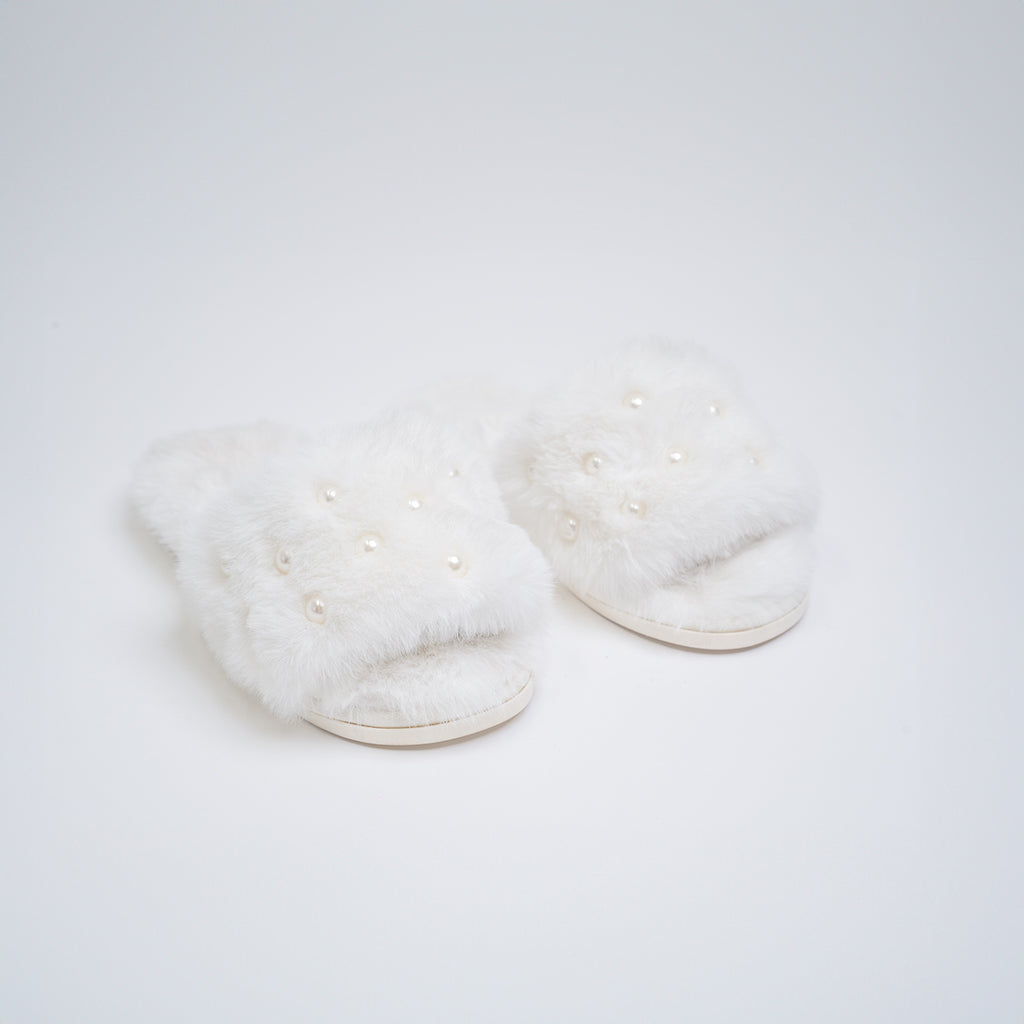 White fluffy slippers on a light gray background