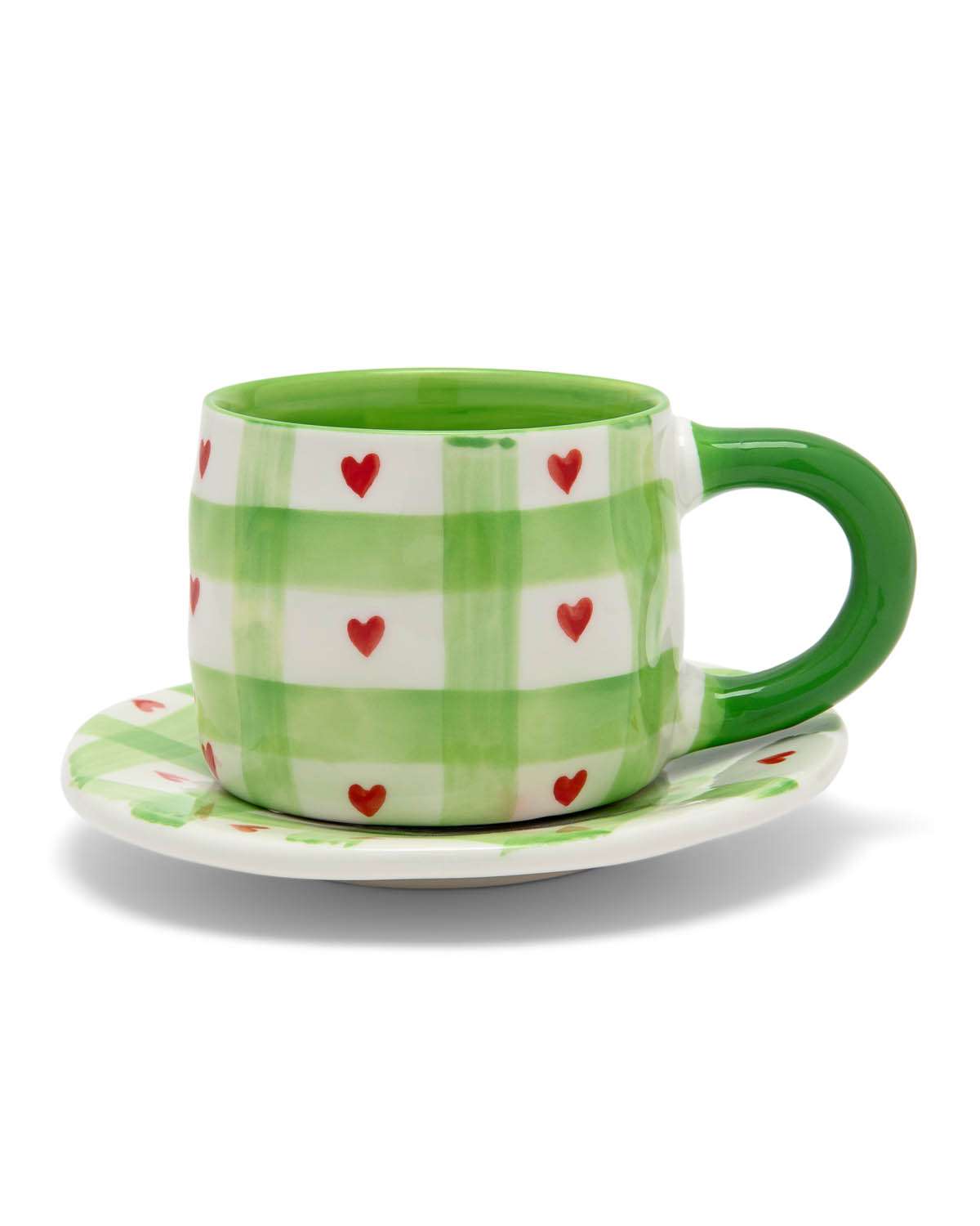 Green mug with red heart pattern on a white background