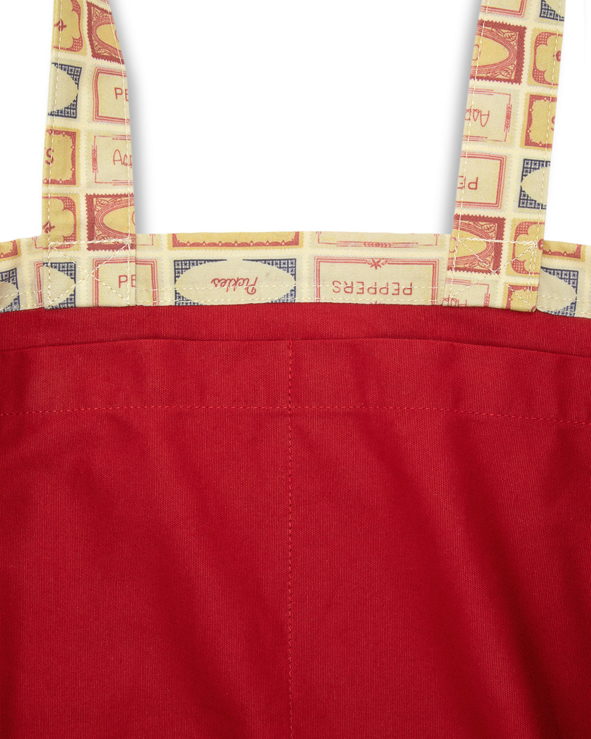 Inside of patterned fabric with vegetable labels of pickles, peppers, tomatoes, asparagus and onions on a white background