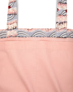 Close-up of the inside pink fabric tote bag with frosting-patterned handles on a white background.
