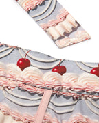 Close up of pink and purple patterned fabric cherry design on a white background